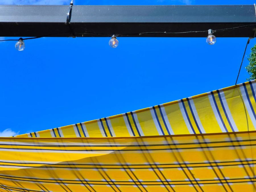 Yellow striped awning against blue sky